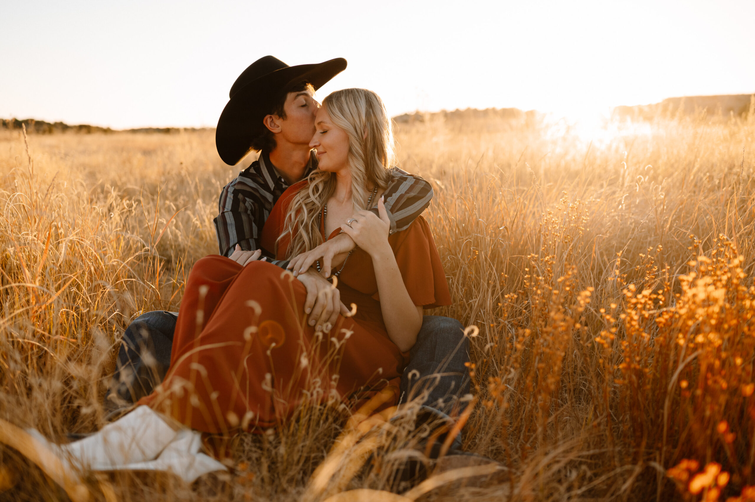 A couple during golden hour snuggled up for engagement photos on their ranch in Southern Colorado.